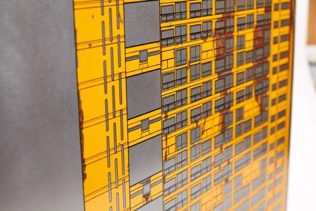 Close-up of an illustration or diagram of a modern building with yellow and gray colors, featuring multiple windows and architectural details.