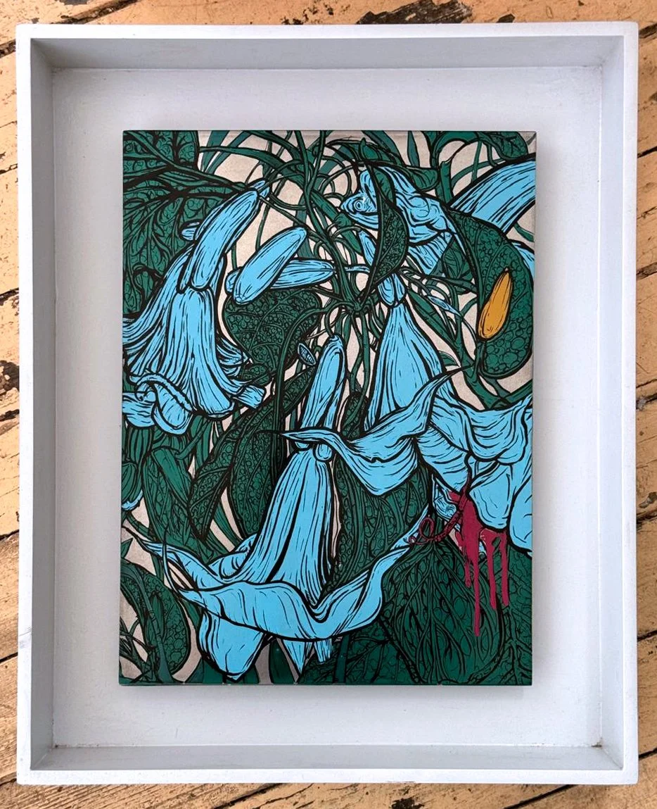 A framed artwork showing blue, bell-shaped flowers and green leaves, with a touch of yellow and red accents.