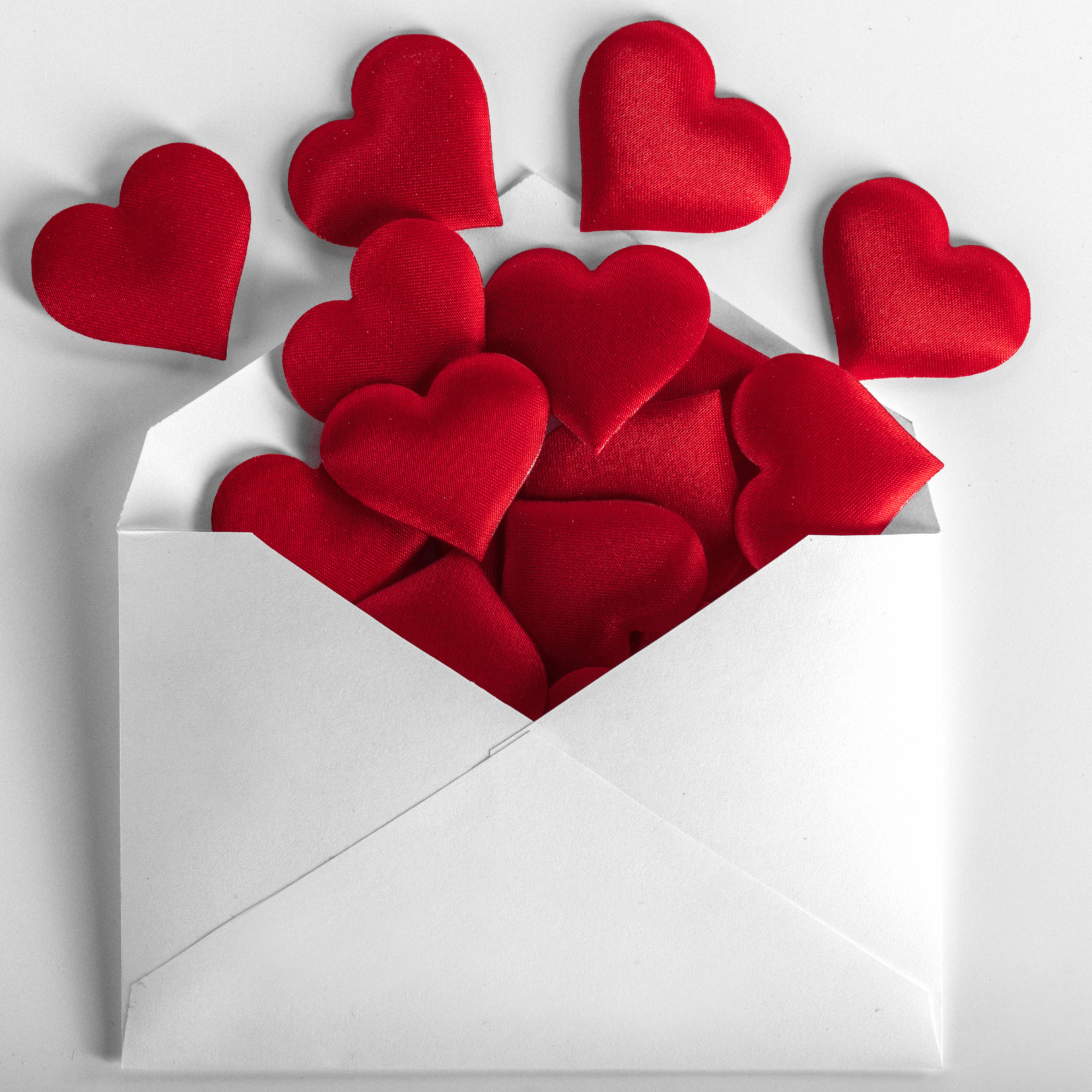 a white envelope with red hearts coming out of it