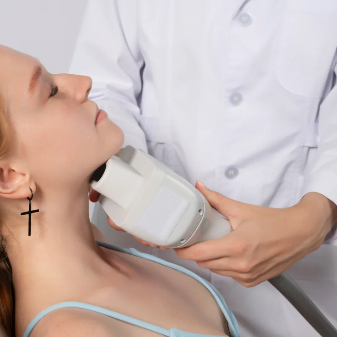 Medical professional performing an ultrasound scan on a woman lying down with her eyes closed.