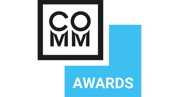 Grafik mit dem Text 'COMMA AWARDS' in Schwarz auf einem schwarzen Hintergrund und einem blauen Pfeil mit dem Wort 'AWARDS' in Schwarz