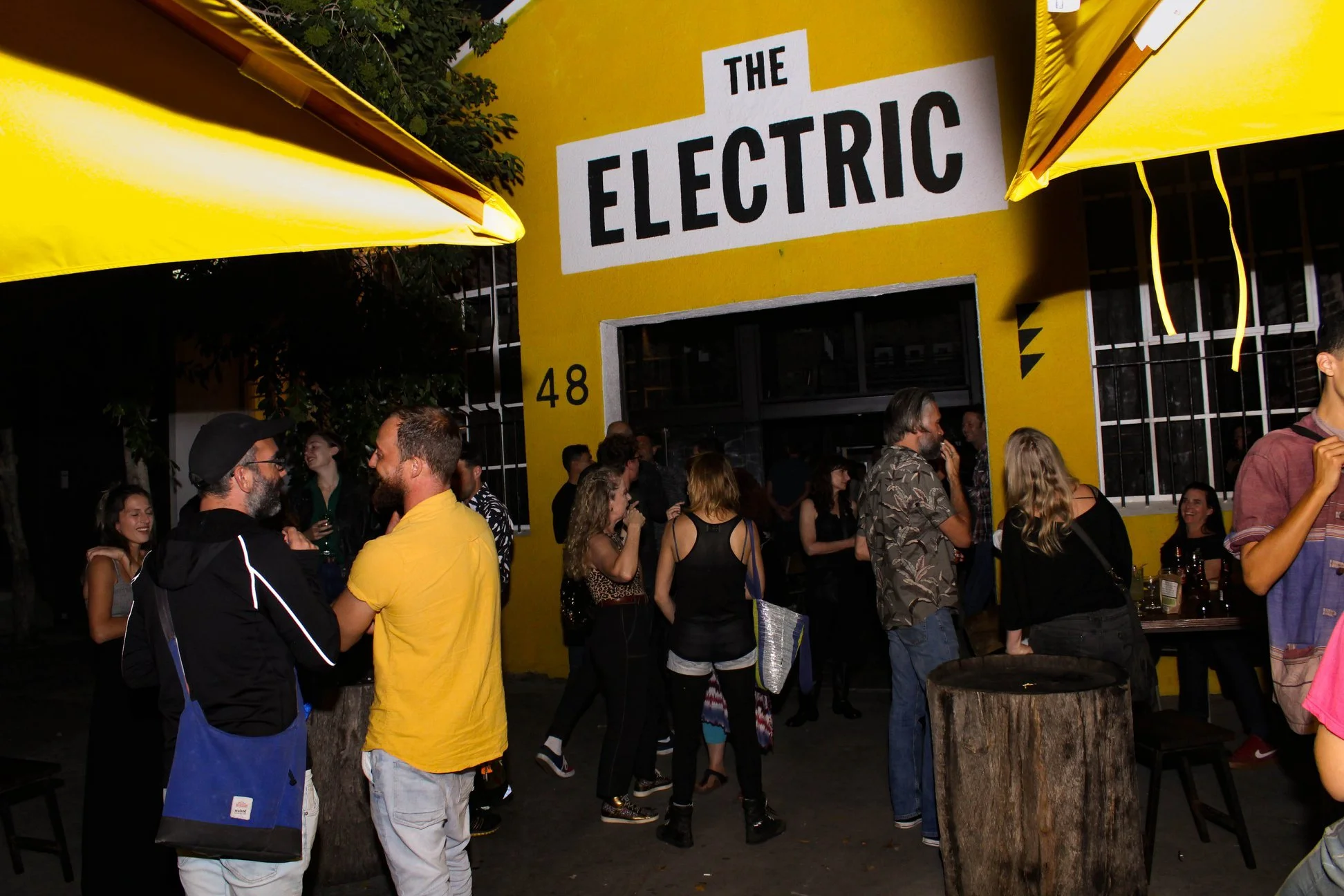 People gathered outside a yellow building with a large sign that reads 'The Electric'.