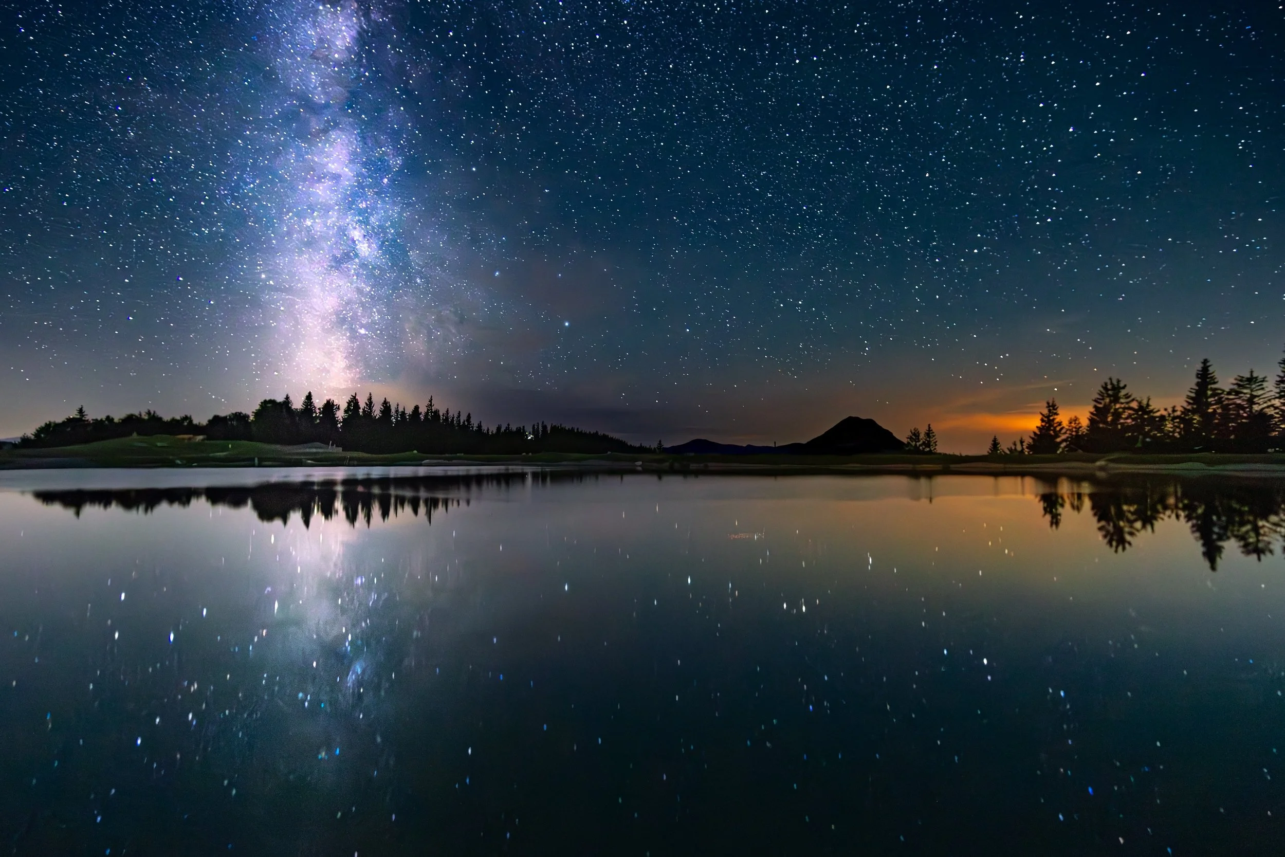 Sterne, Milchstraße und Spiegelung im Wasser bei Nacht in der Natur.