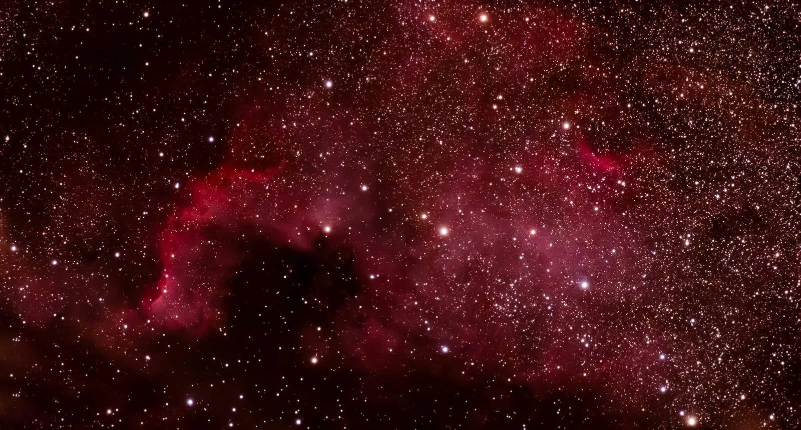 Sternenhimmel mit roten Gasnebeln und vielen Sternen im Universum