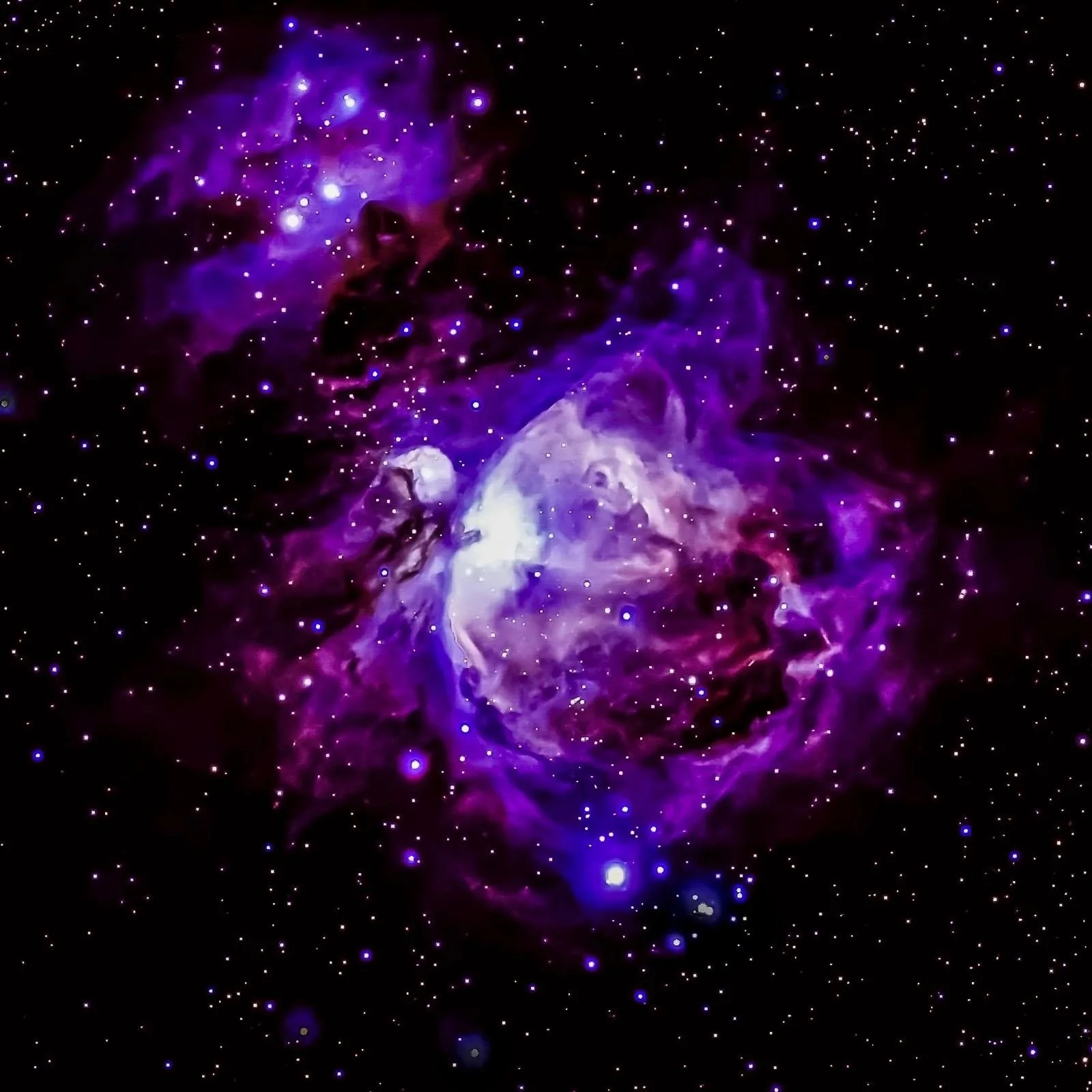 Ein farbenfrohes Bild des Weltraums mit leuchtenden Nebeln und vielen Sternen in violetten und blauen Tönen.