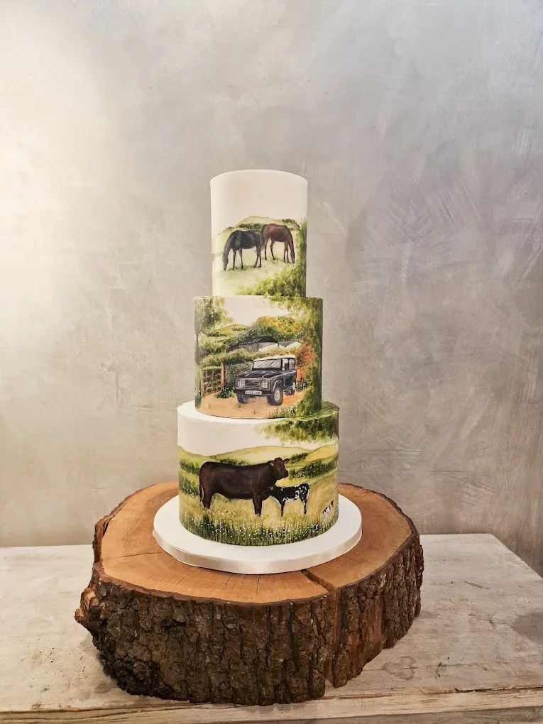 Three-tiered cake with painted farm scenes, including horses on the top tier, a truck on the middle tier, and a cow with a calf on the bottom tier, placed on a tree stump.