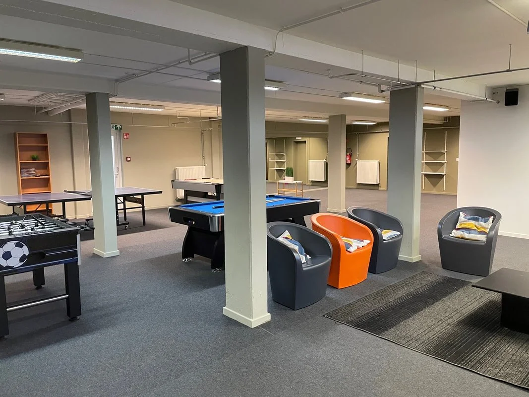 Een speelhoek met biljarttafel, tafeltennistafel en een poolbiljart in een ontspanningsruimte.