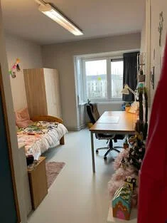 Kamer met bed, tafel, stoelen, en een raam met uitzicht, decoraties en een kast.