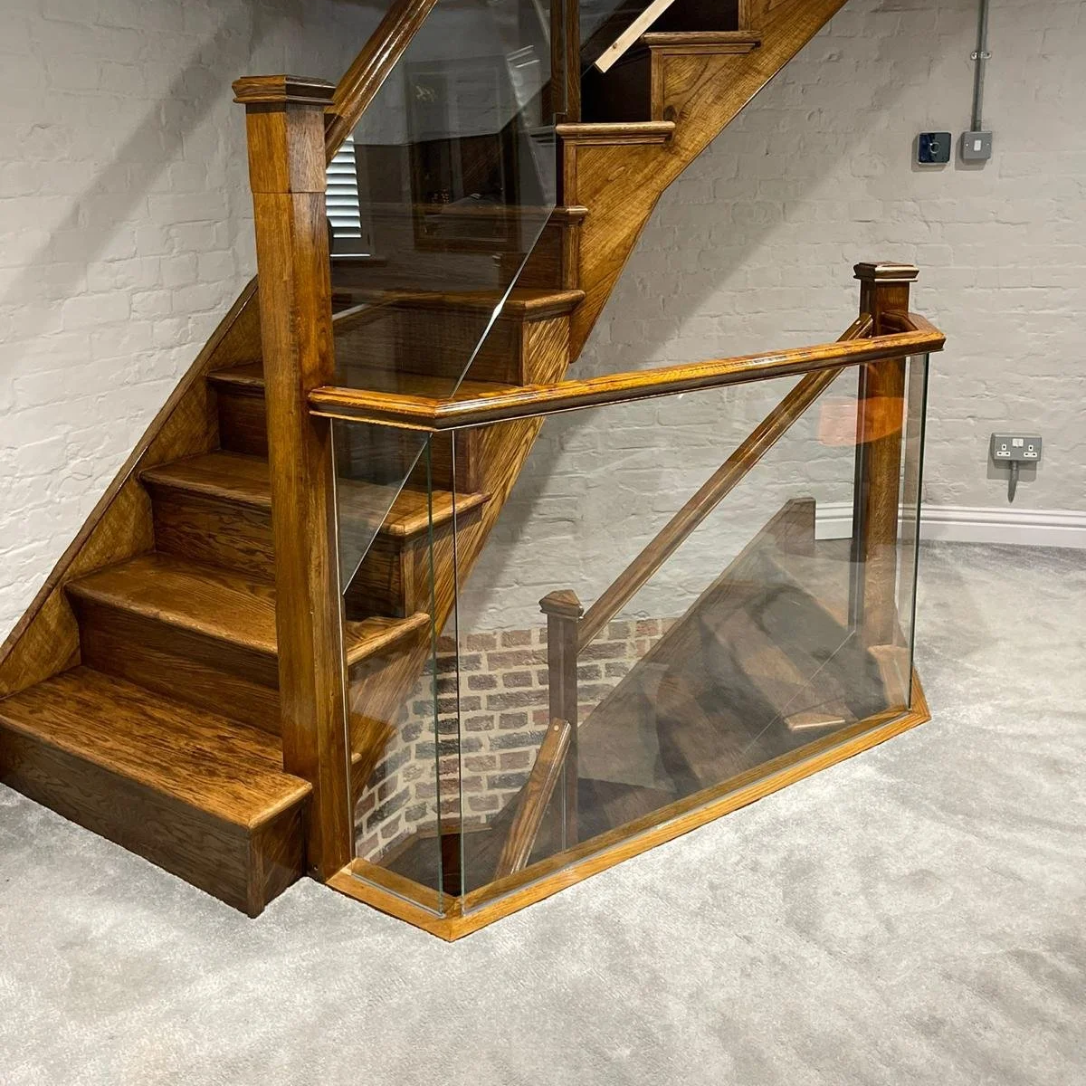 Wooden staircase with glass balustrades in a modern interior.