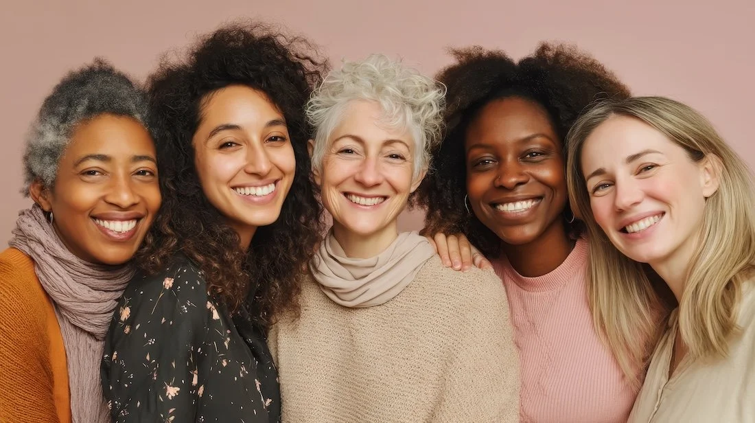Fashion designer taking measurements of a model's shoulder with a measuring tape in a fitting room.