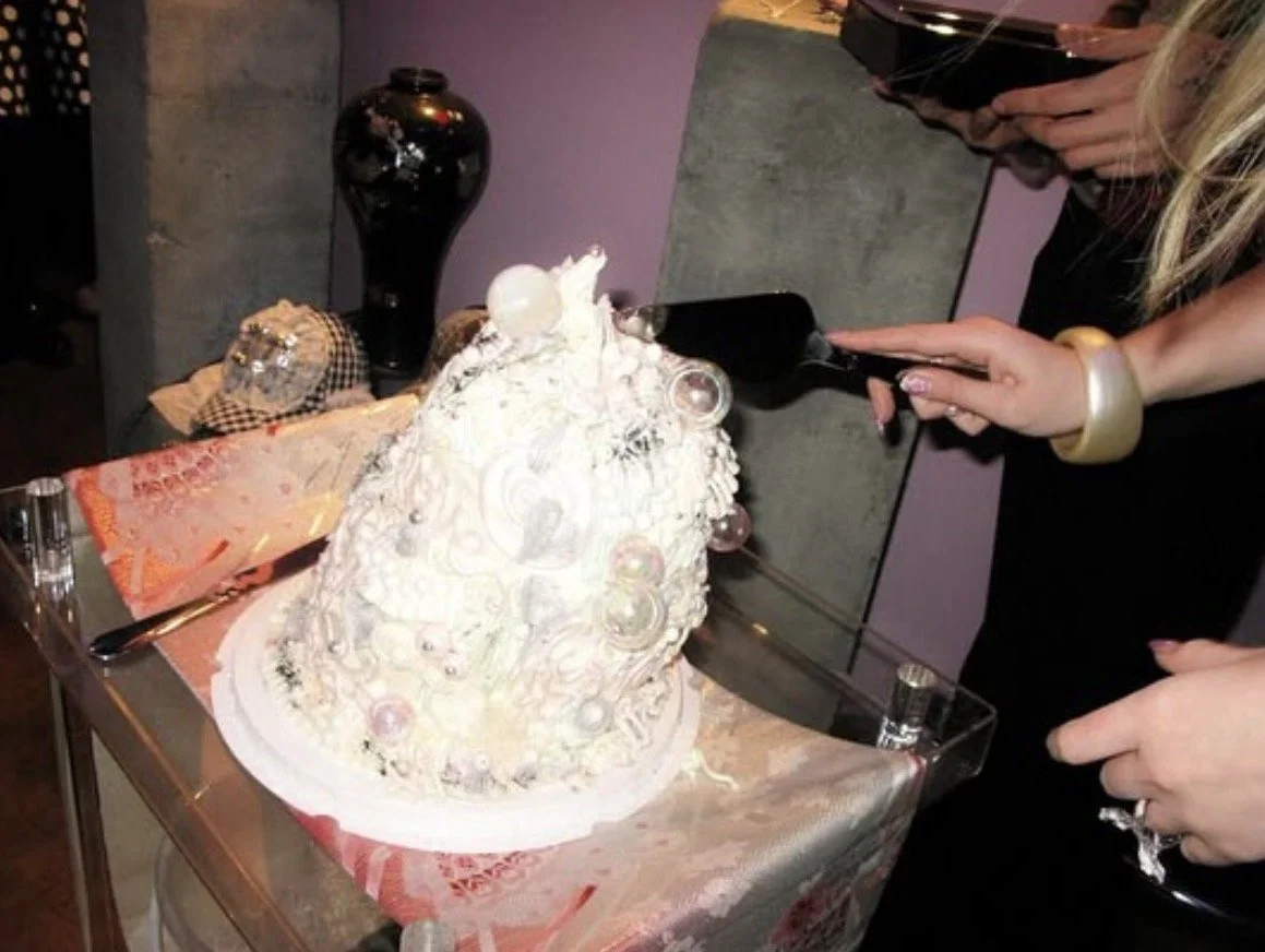 A cake with white frosting and decorative elements 