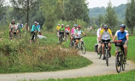 Gruppe von Radfahrern, die auf einem Weg in der Natur unterwegs sind.