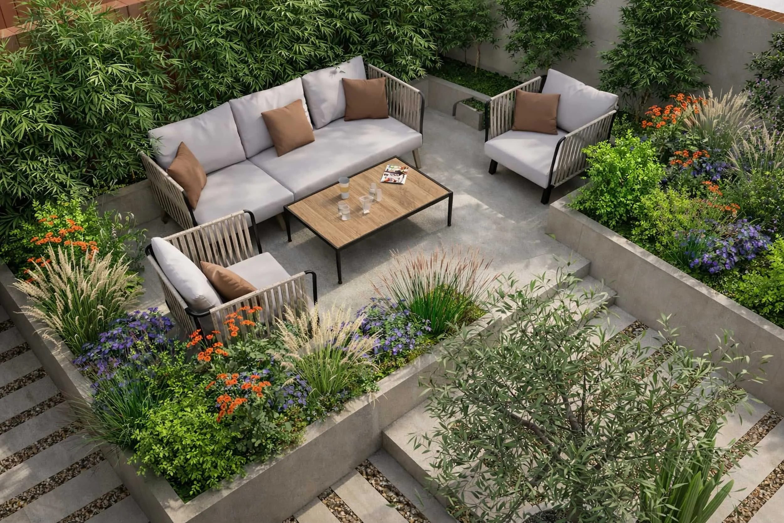 Overhead view of a structured, planting-led garden featuring a central outdoor seating area framed by raised concrete planters filled with ornamental grasses, flowering perennials and evergreen screening.