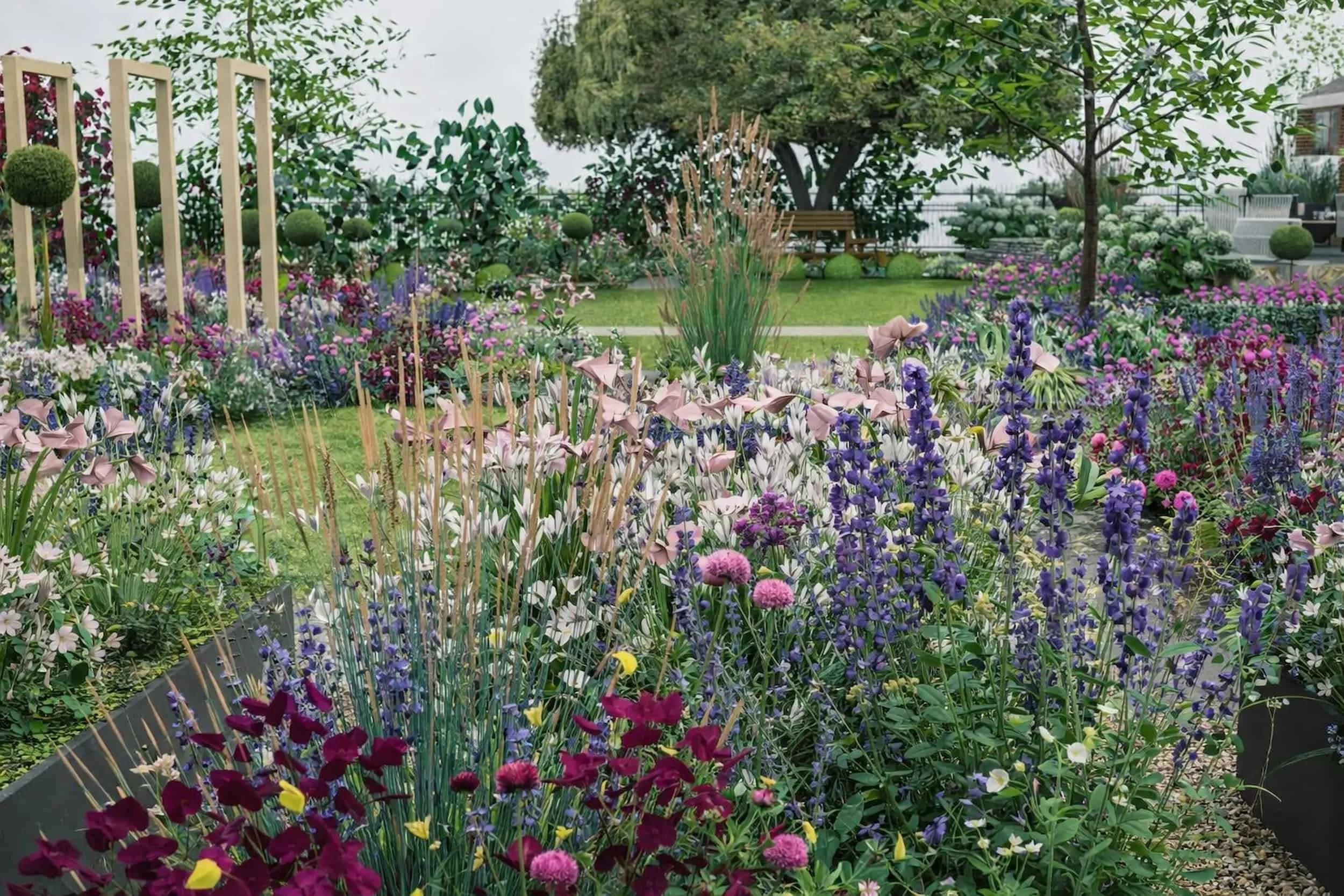 Country side large garden with curved path ways, wooden timber archways, topiary lollipop trees and cottage style planting. Pink, purple and white