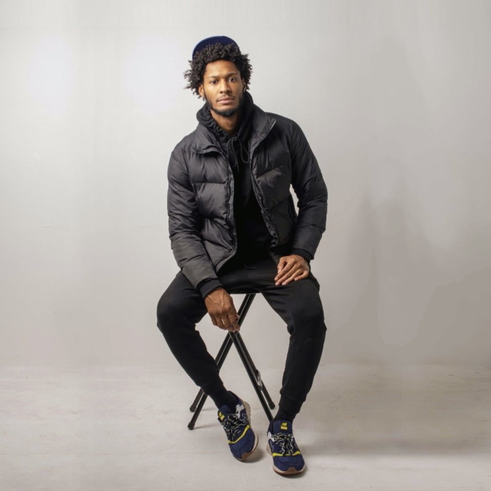 Studio portrait of a man seated on a stool against a light gray backdrop at 4 Snaps Studios in Cincinnati