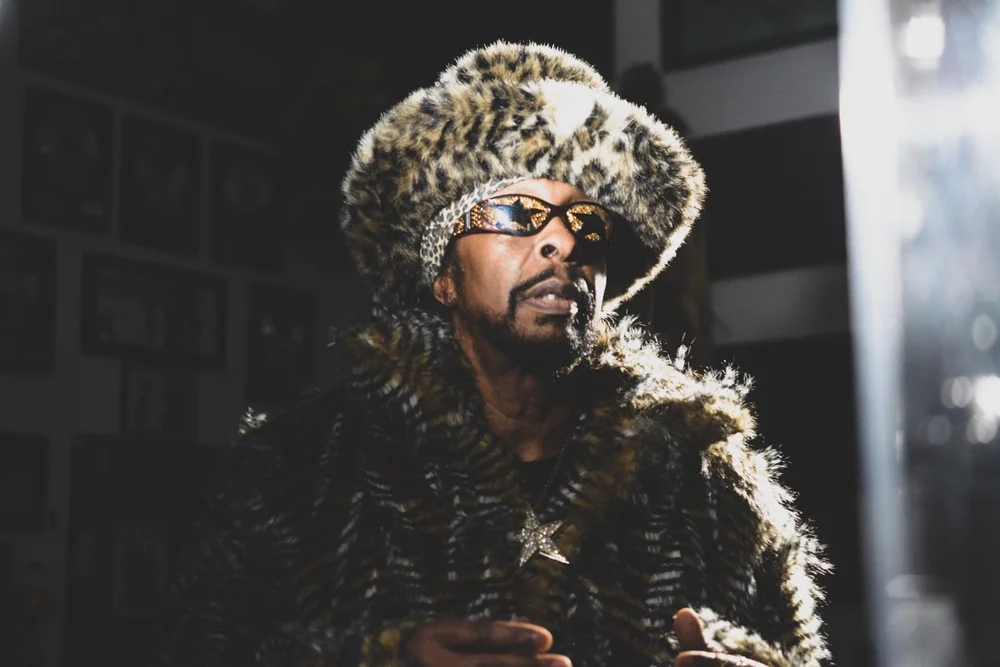 Creative portrait of an artist in a fur hat under dramatic lighting