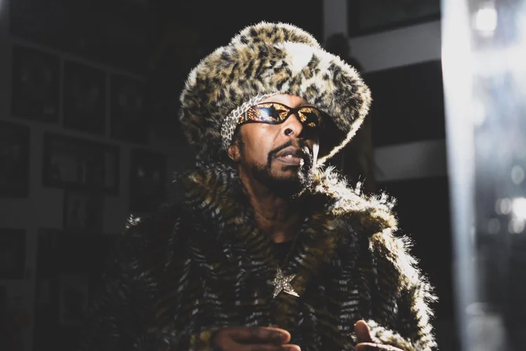 Creative portrait of an artist in a fur hat under dramatic lighting