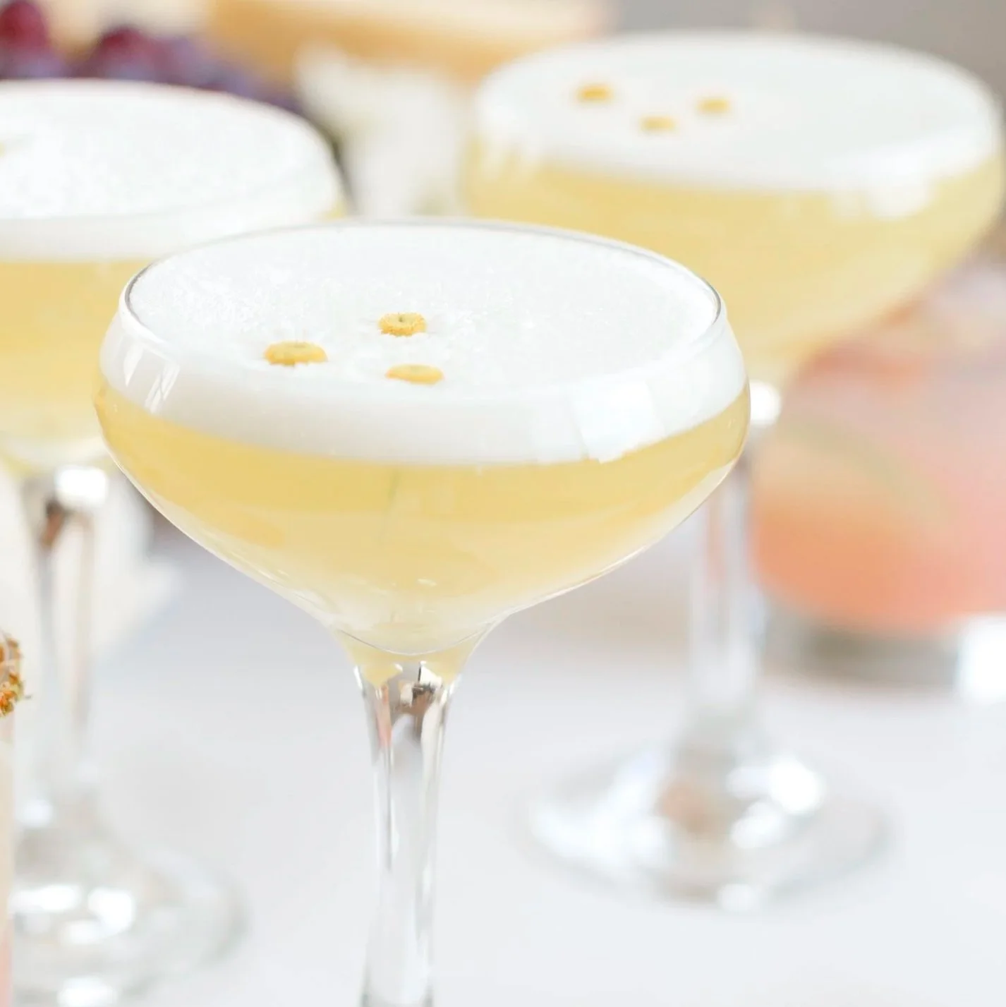 yellow and pink cocktail in a clear glass