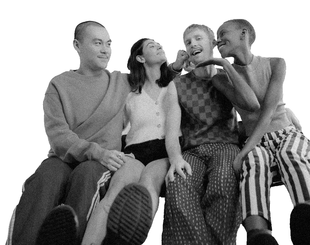 Four diverse friends sitting closely, sharing a joyful moment, with three smiling and one that appears to be playfully poking or touching the other's face, all in casual clothing.