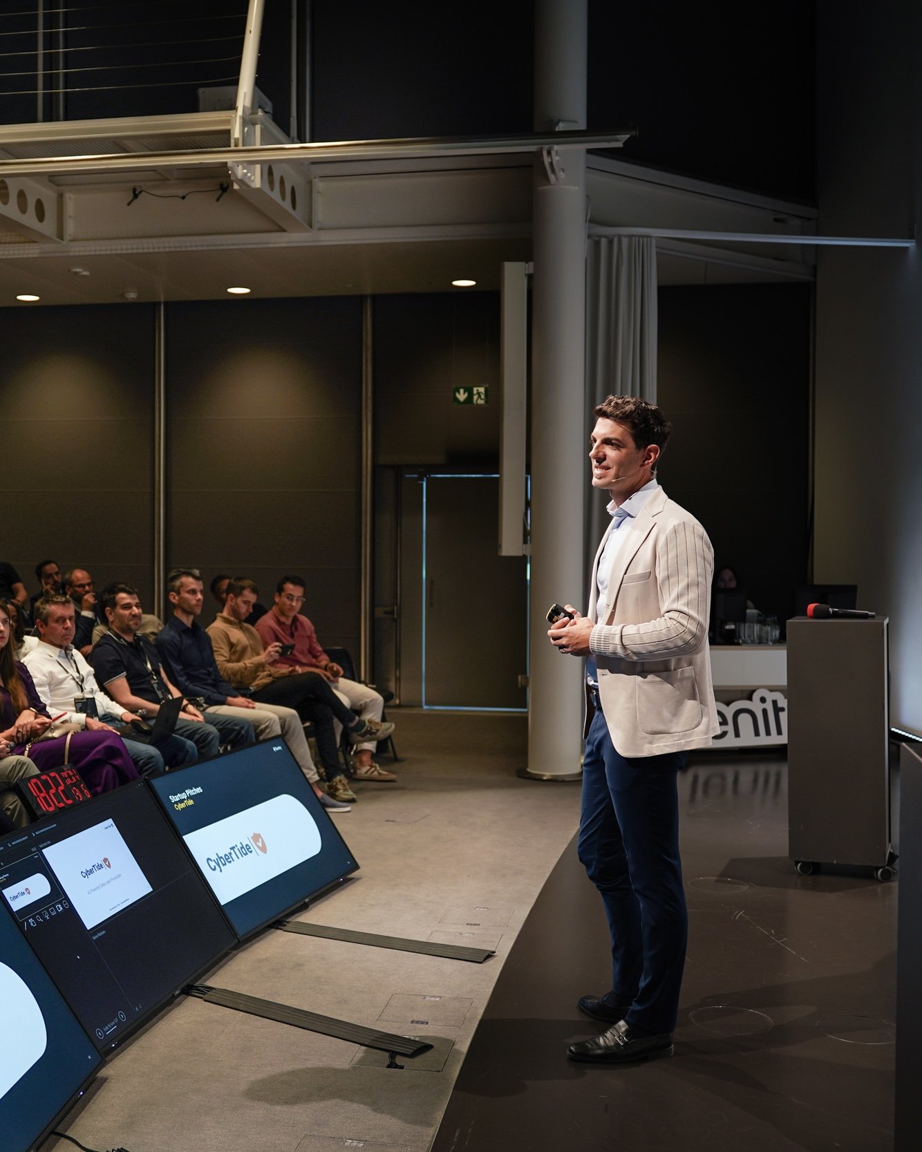 Ein Mann hält eine Präsentation vor einem Publikum in einem Konferenzraum.