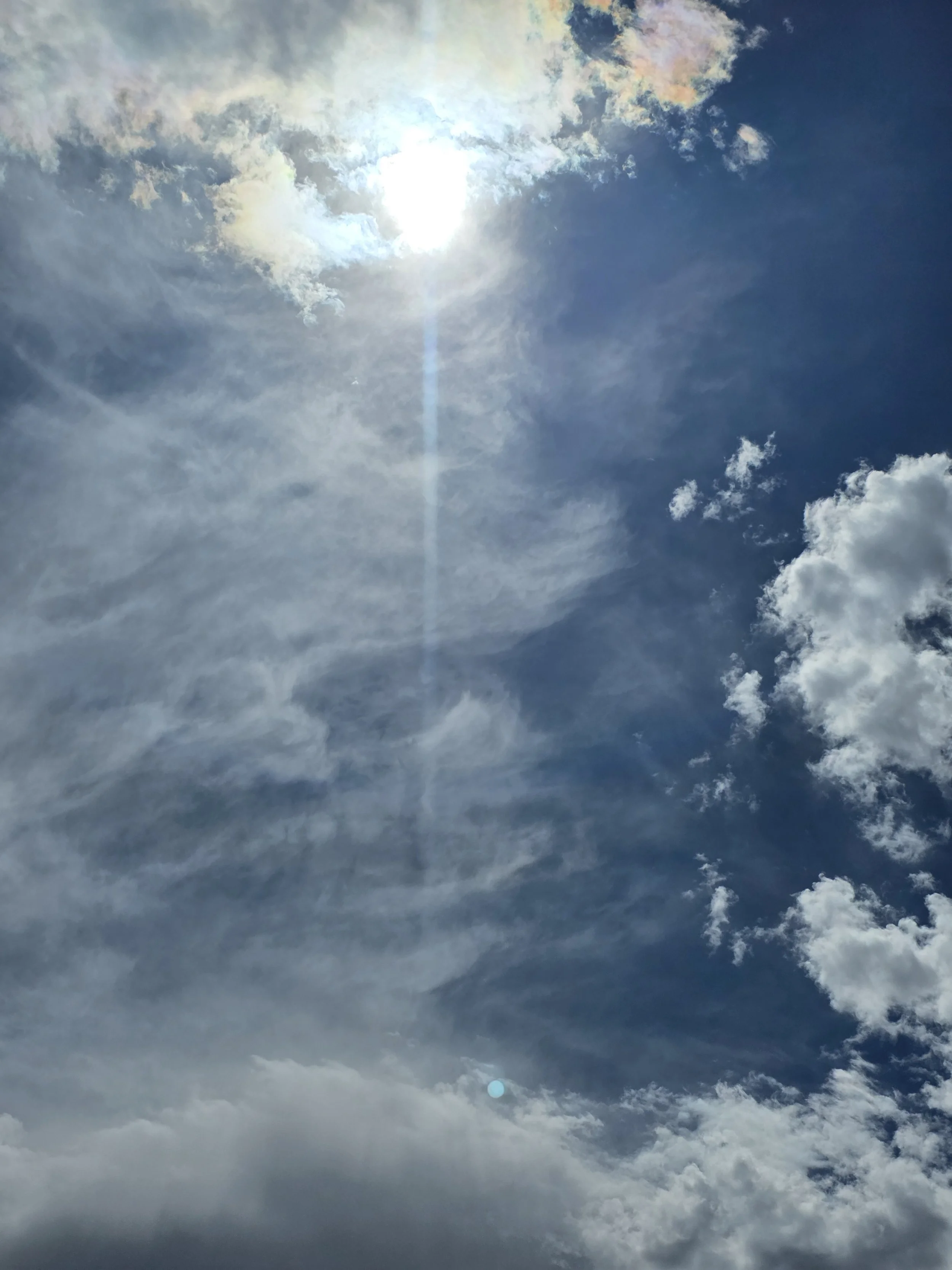 A picture of the Sun and clouds in the sky.