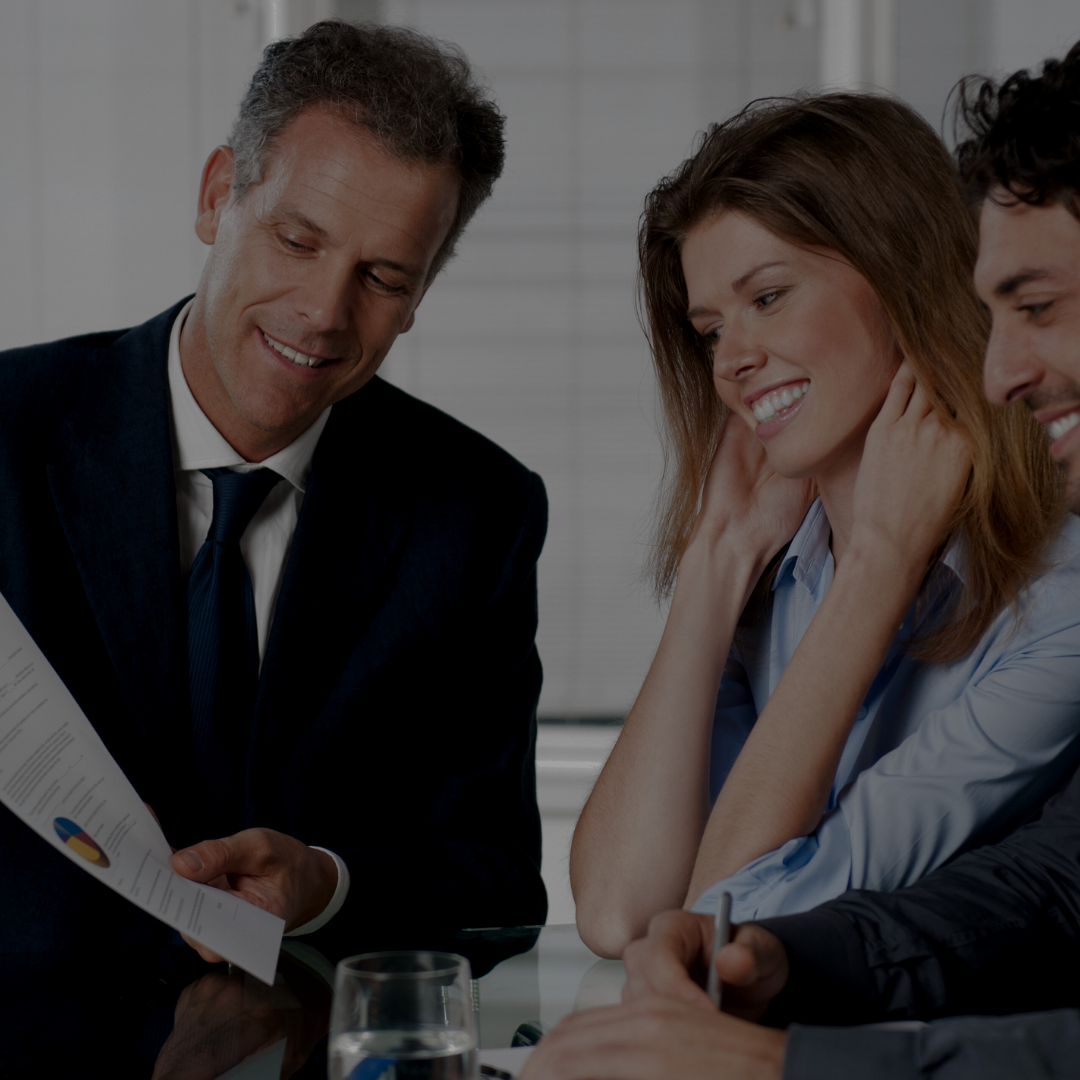 Group of four business professionals happily discussing in a meeting