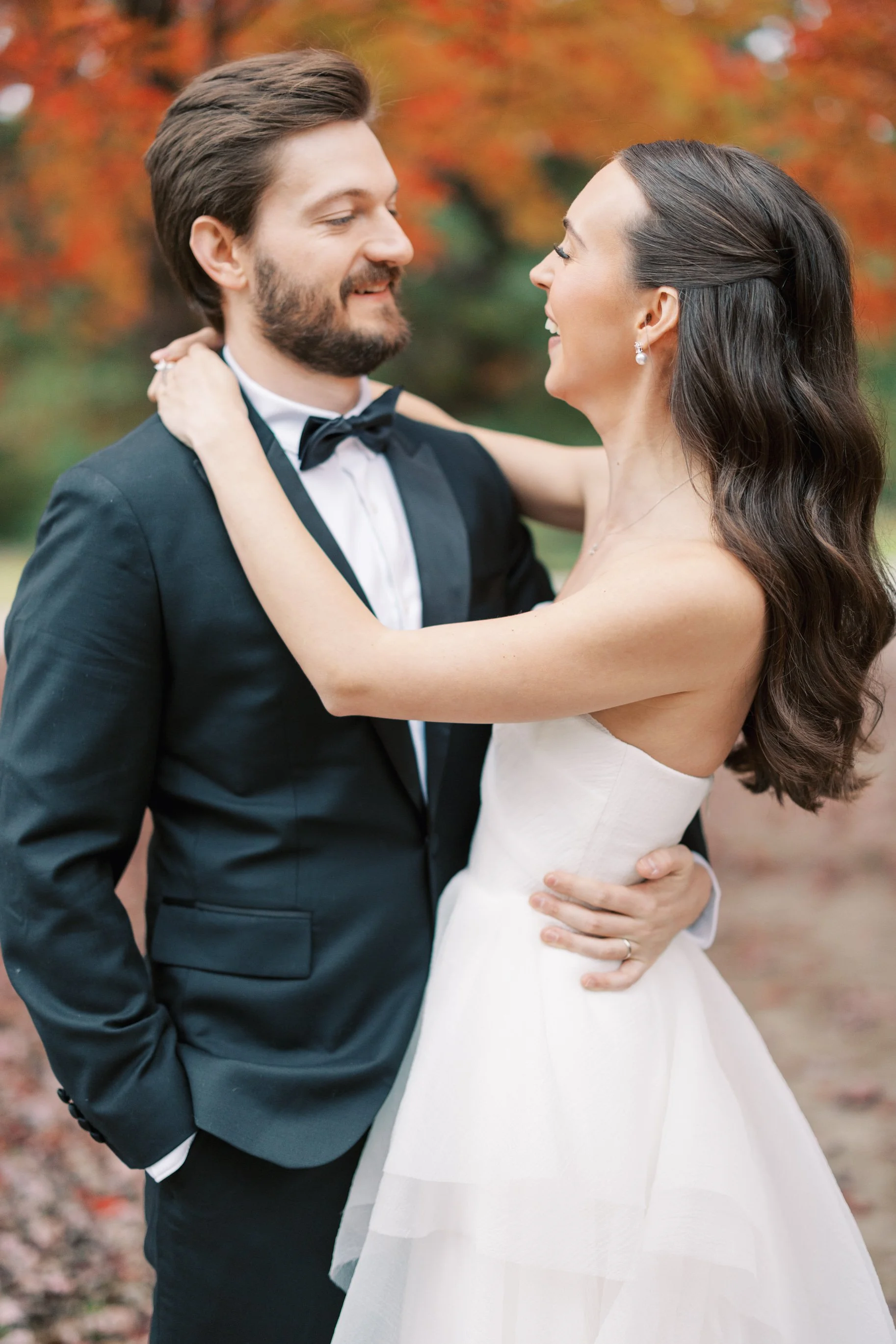 A married man and woman in a white dress laughing after getting married. Bridal hair and makeup by professional makeup artist, Carly Amico of Carly Marie Artistry, a makeup artist in Charlotte NC.