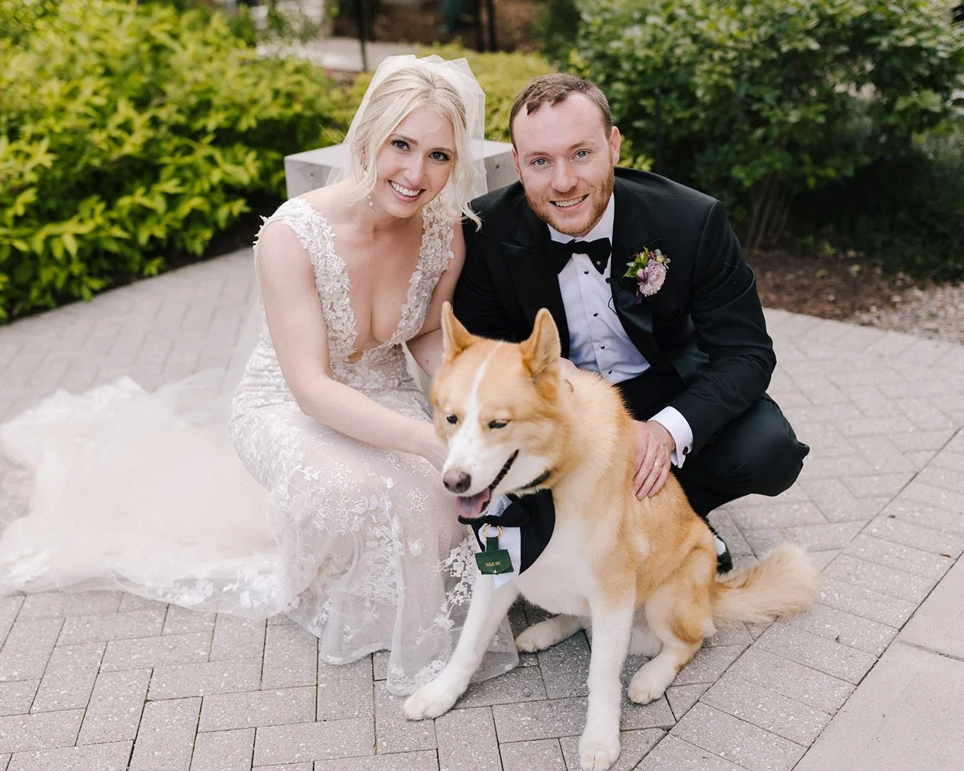 Bride and groom smiling with their dog during wedding day portraits in Charlotte NC