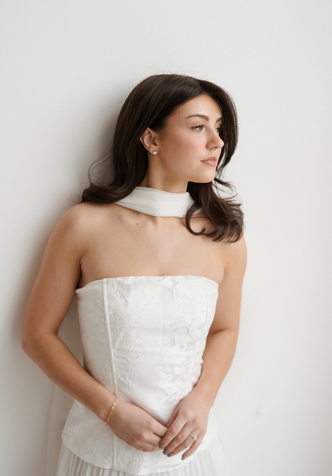 A woman in a white dress staring out the windown before getting married. Bridal hair and makeup by professional makeup artist, Carly Amico of Carly Marie Artistry, a makeup artist in Charlotte NC.
