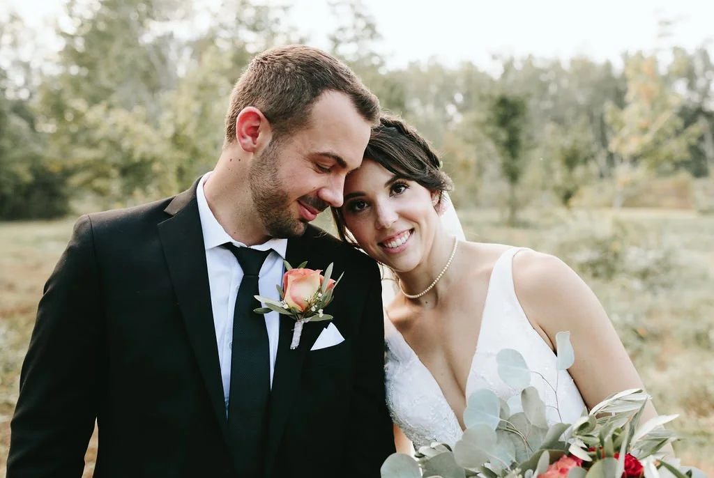 Bride and groom sharing romantic moment outdoors with natural bridal makeup by Carly Marie Artistry