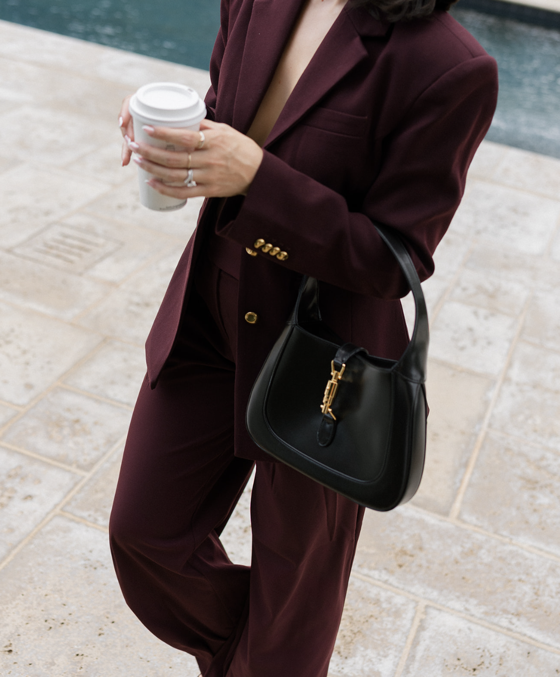 Close-up of burgundy suit, black handbag, and coffee cup — modern makeup artist branding photo