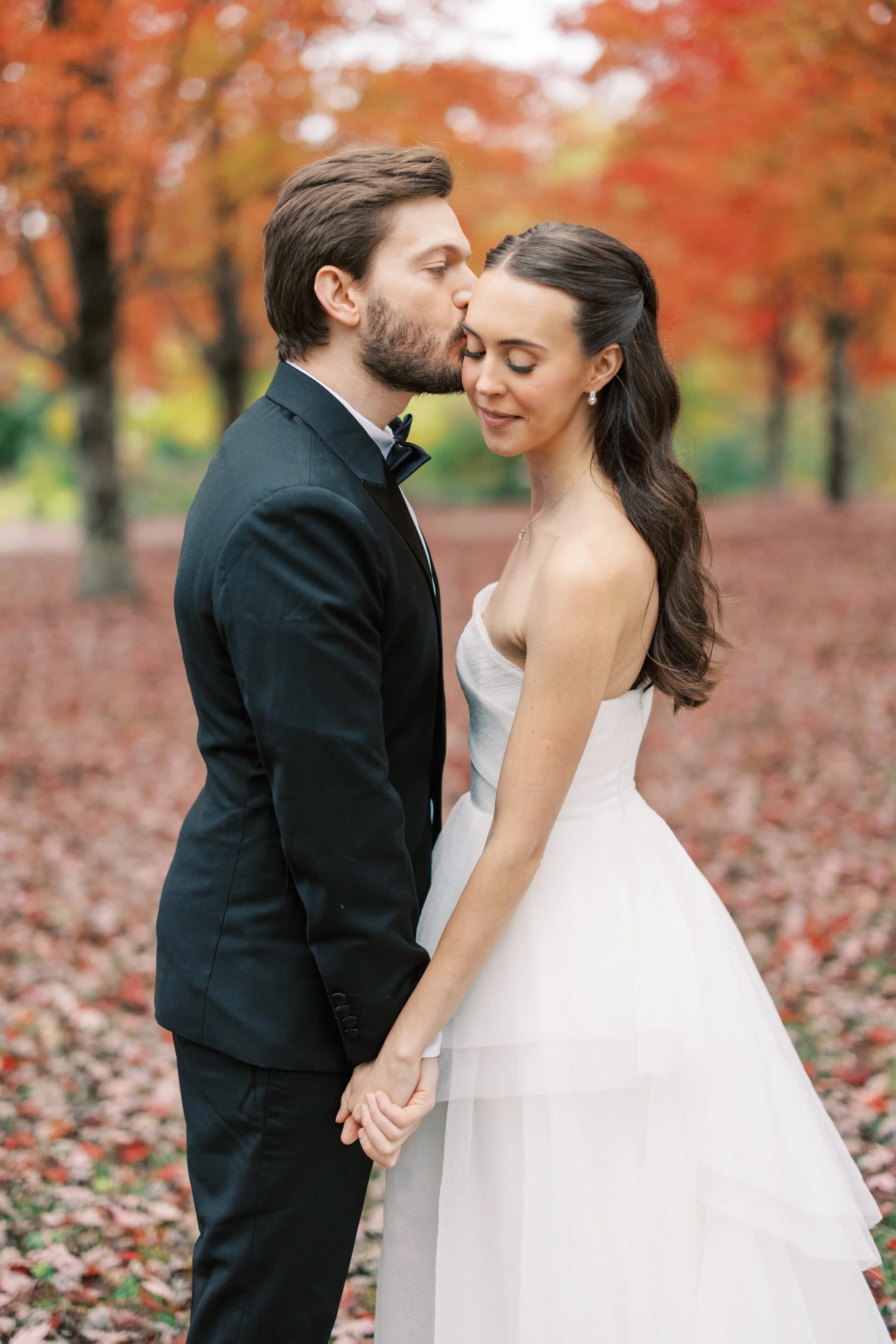 A woman in a white wedding dress taking holding her husbands hand after getting married. Bridal hair and makeup by professional makeup artist, Carly Amico of Carly Marie Artistry, a makeup artist in Charlotte NC.