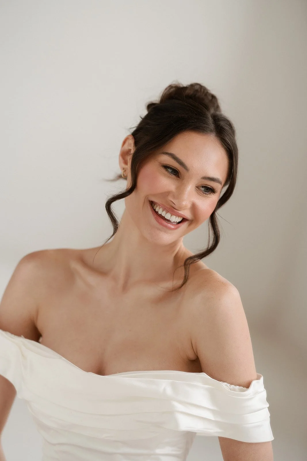 A woman in a white wedding dress smiling after getting married. Bridal hair and makeup by professional makeup artist, Carly Amico of Carly Marie Artistry, a makeup artist in Charlotte NC.