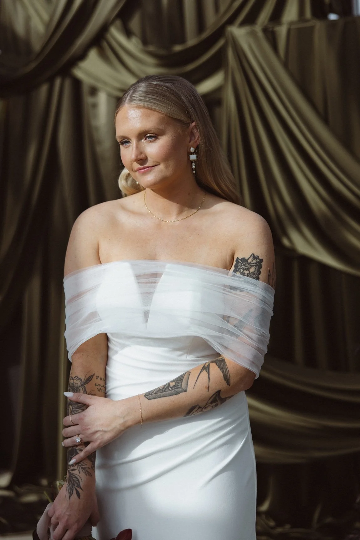 Tattooed bride with soft glam makeup in off-shoulder gown, styled by Carly Marie Artistry