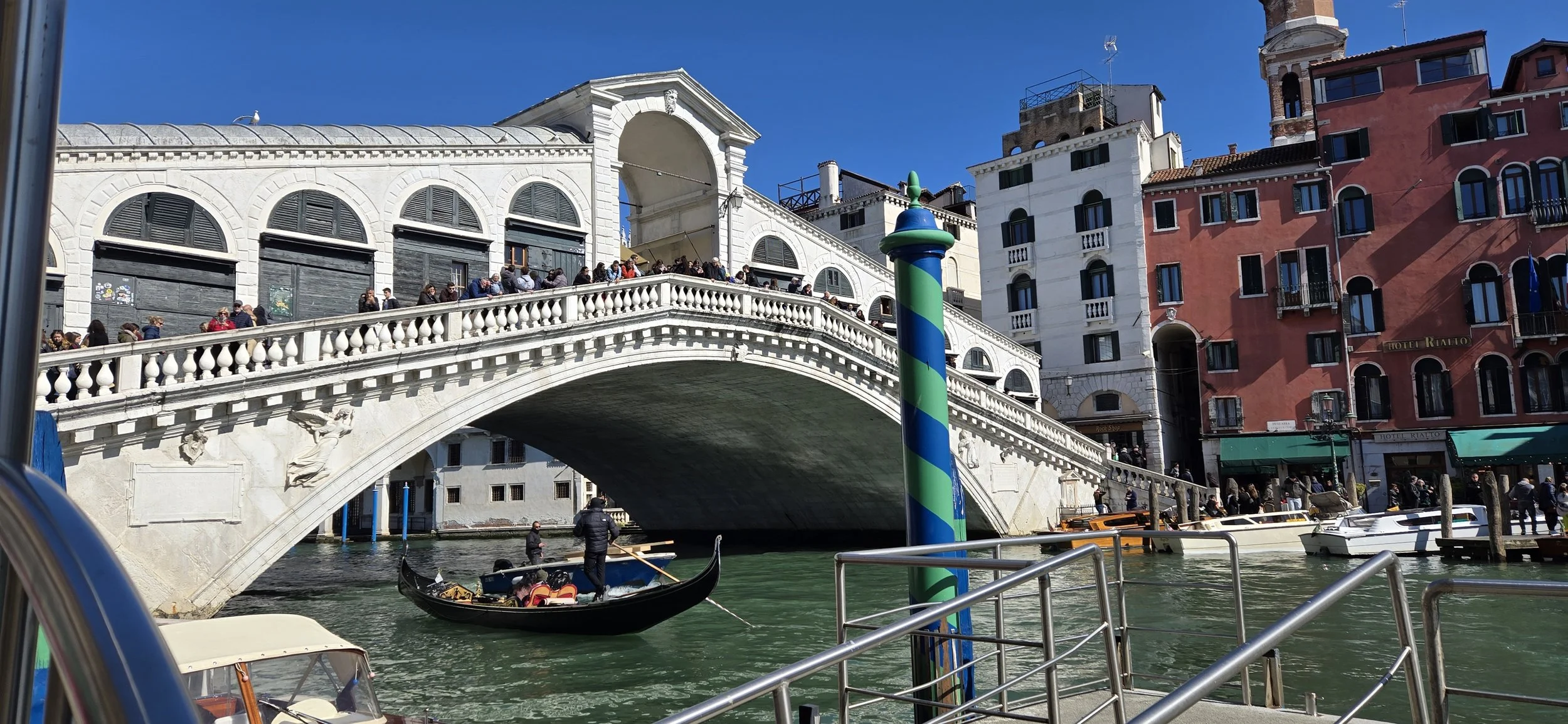 Gondola on water near a historic bridge with architecture and buildings in Venice, Italy.