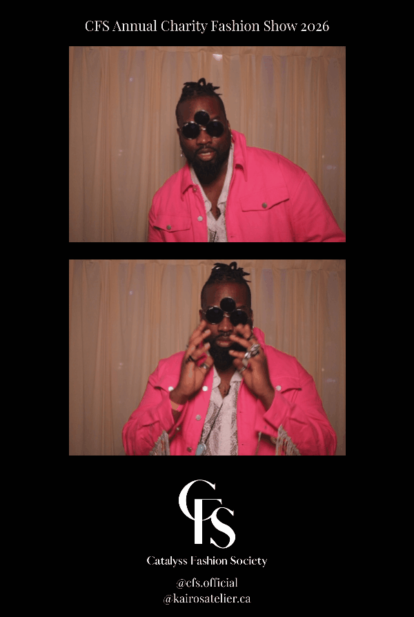 A man with a beard in a pink jacket and sunglasses, posing in front of beige curtains at the CFS Annual Charity Fashion Show 2026, with the event details and logo of Catalyst Fashion Society.