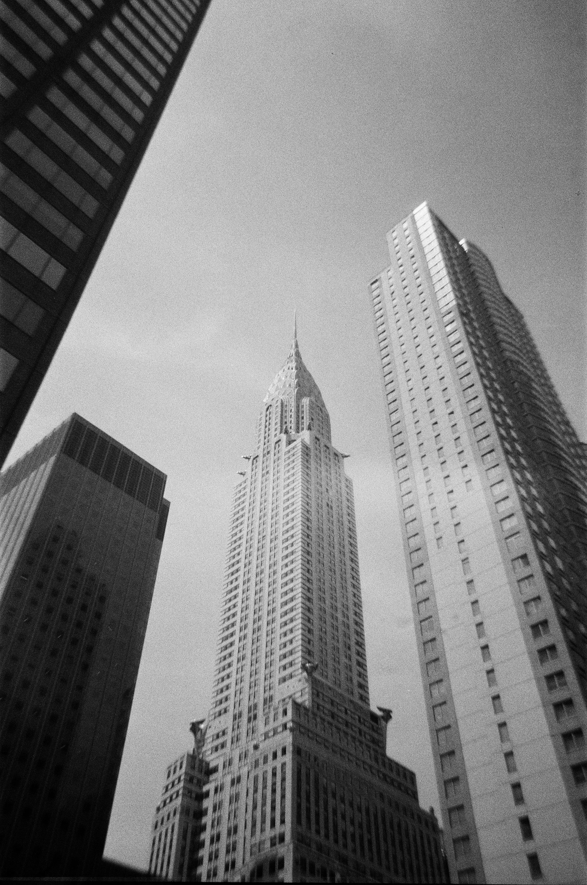Black and white photo of skyscrapers in a city, with the Empire State Building at the center.