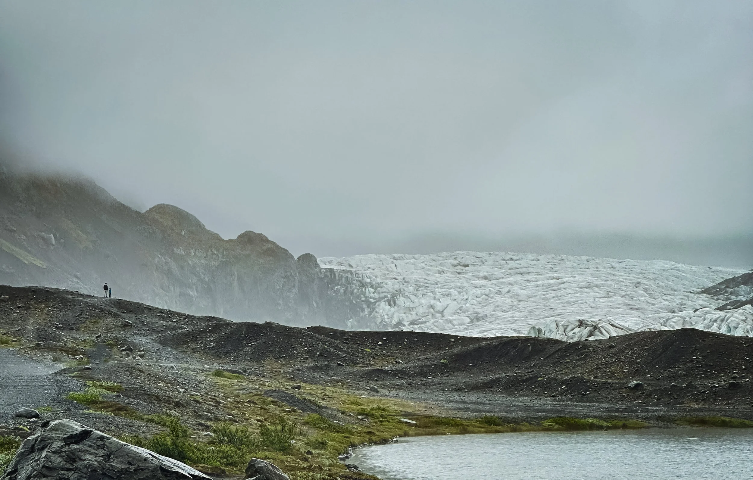 Two figures looking out at Svínafellsjökull Glacier in Iceland