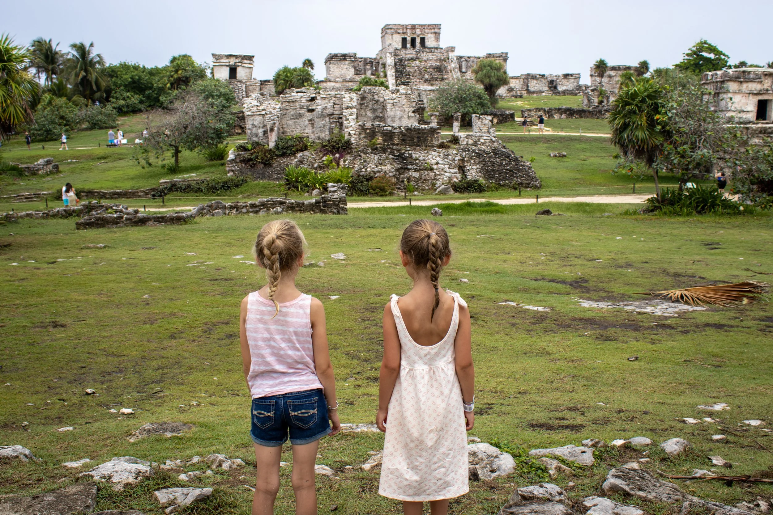 Two girls looking at the ruins of the city of Tulum in Mexico