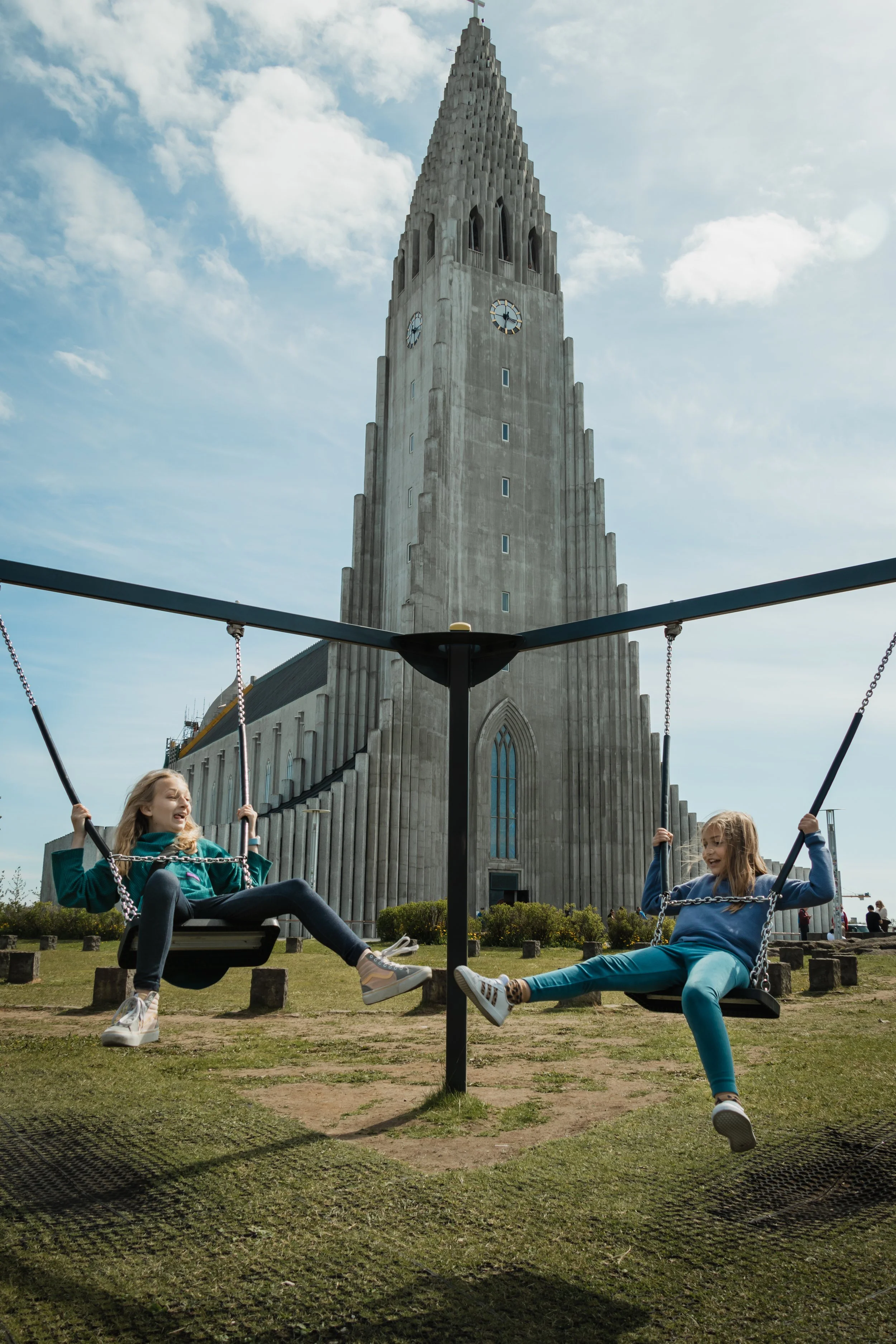Girls swinging in front of Hallgrímskirkja Church in Reykjavik, Iceland