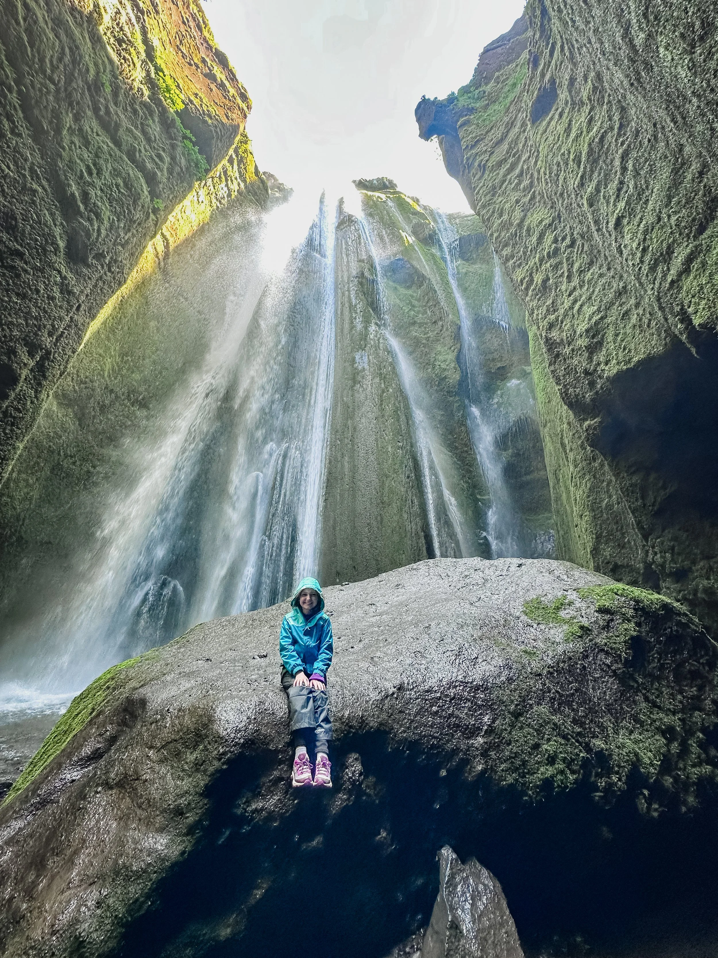 Sitting under the Gljúfrabúi waterfall in Iceland