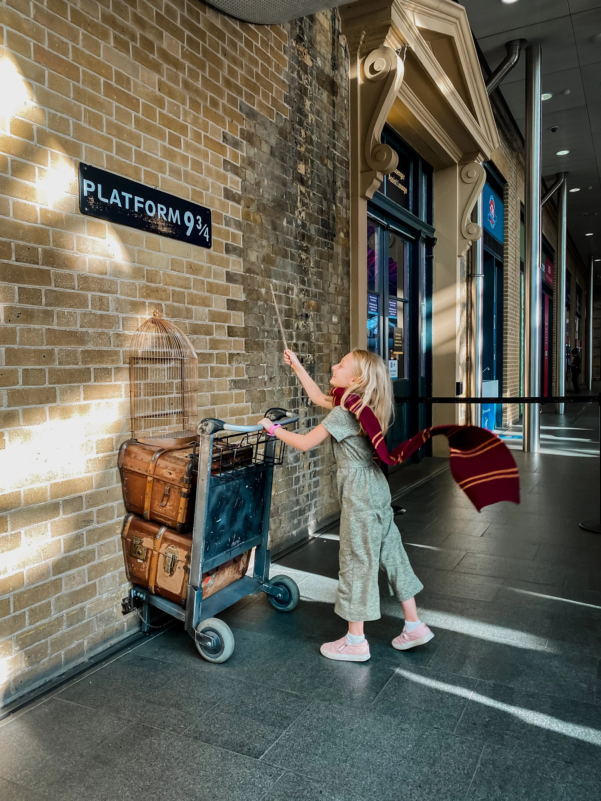 A Gryffindor student walking onto the Platform 9 3/4 at Kings Cross Station in London.