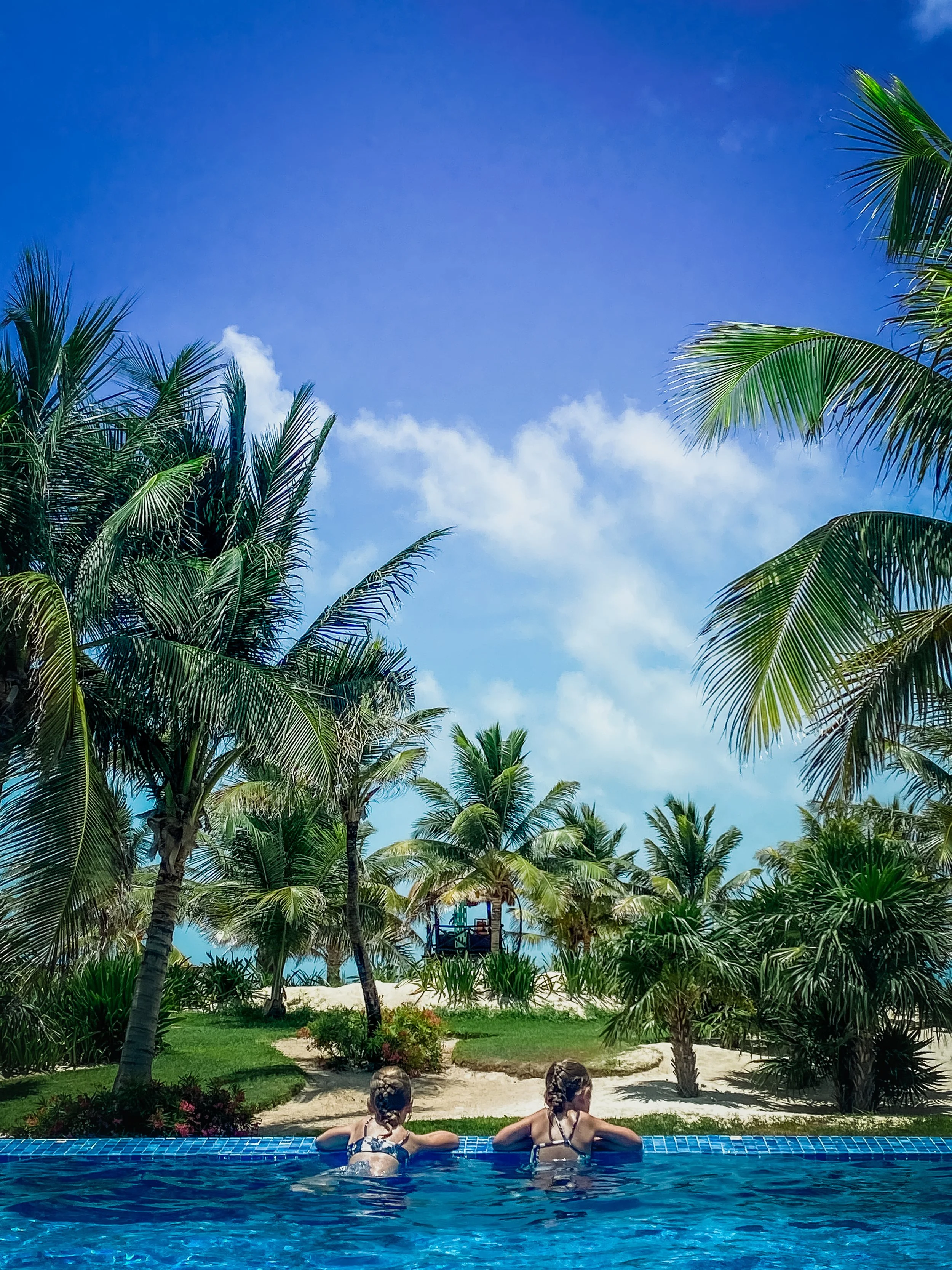 Two girls looking towards the beach from the pool in Cancun Mexico