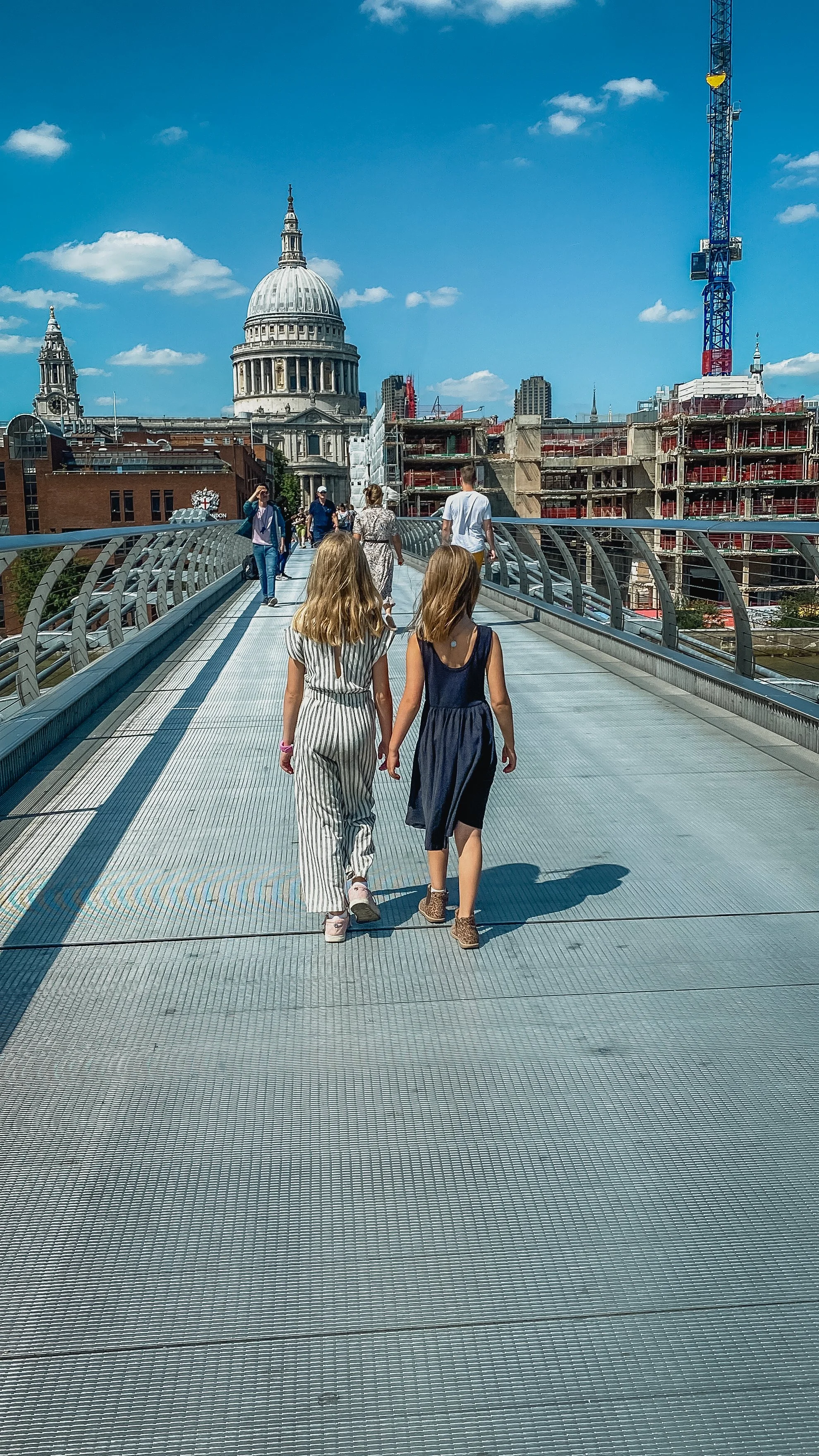girls walking on Millennium Bridge towards St. Paul's Cathedral