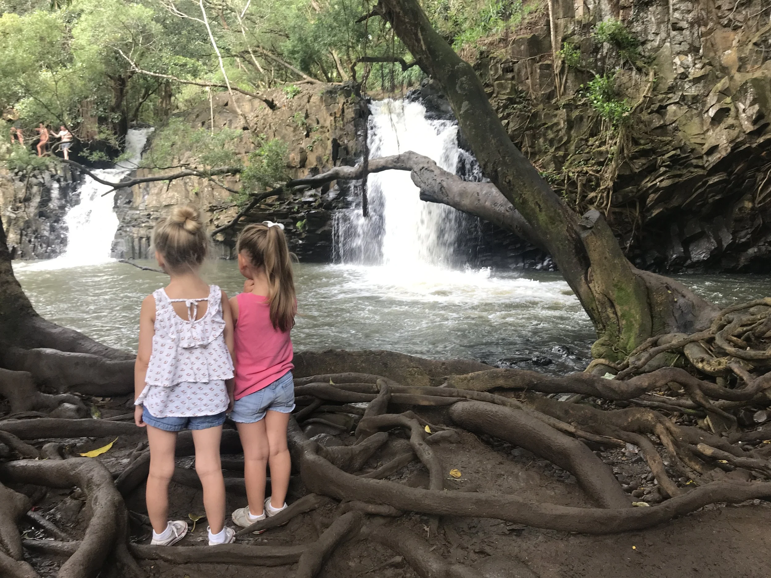 Two girls looking at Twin Falls on the Road to Hana in Maui Hawaii