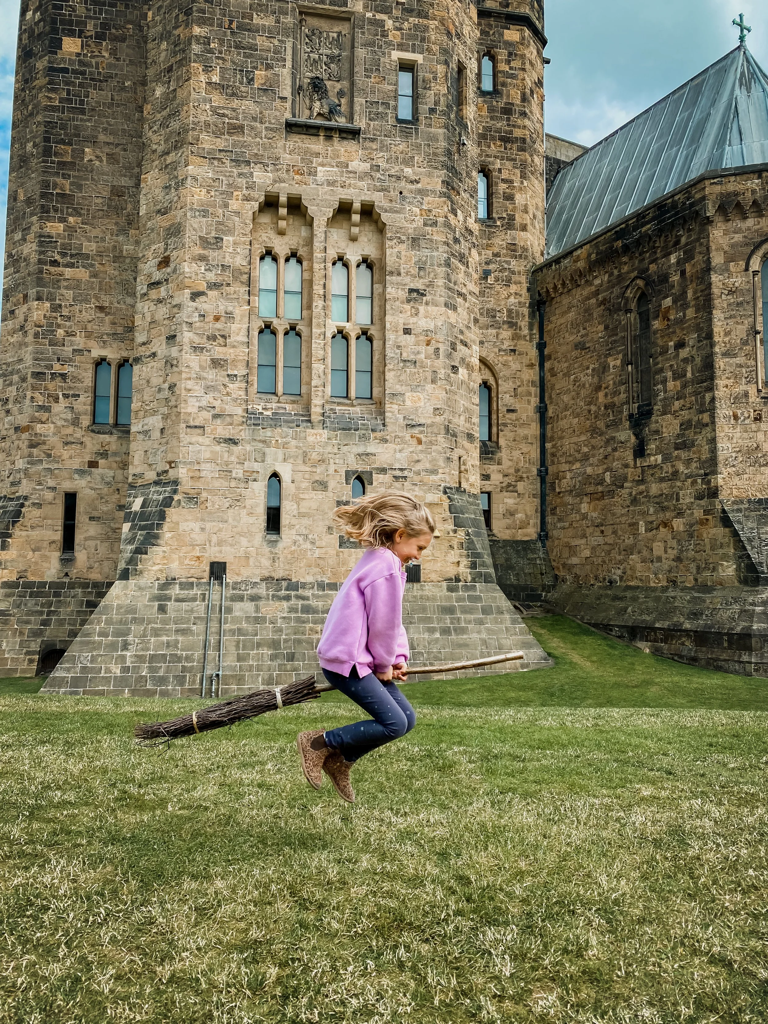 A girl flying on a broomstick at Alnwick Castle, where Harry Potter learned to fly in the Harry Potter films.
