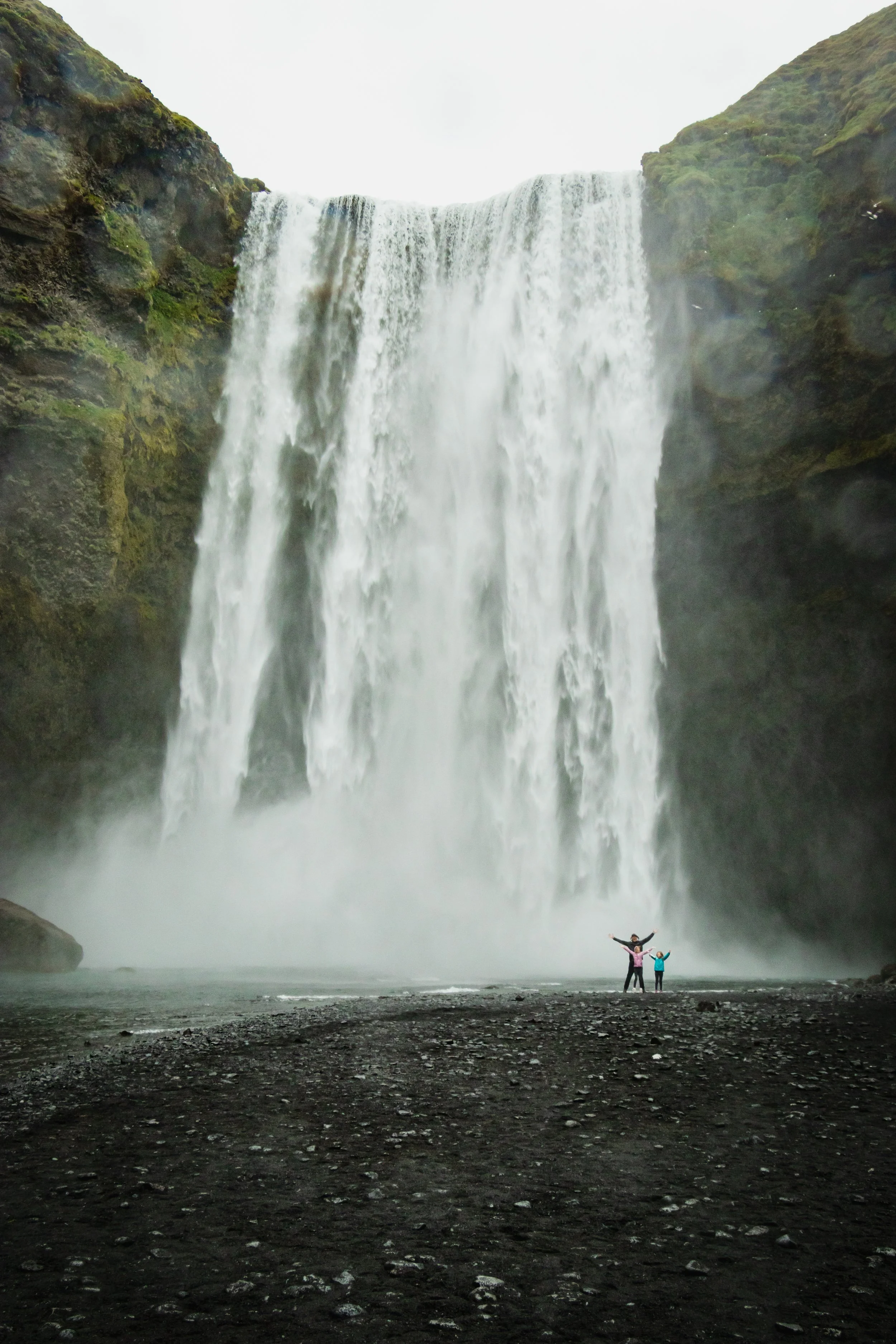 Standing in the mist of Skógafoss waterfall in Iceland