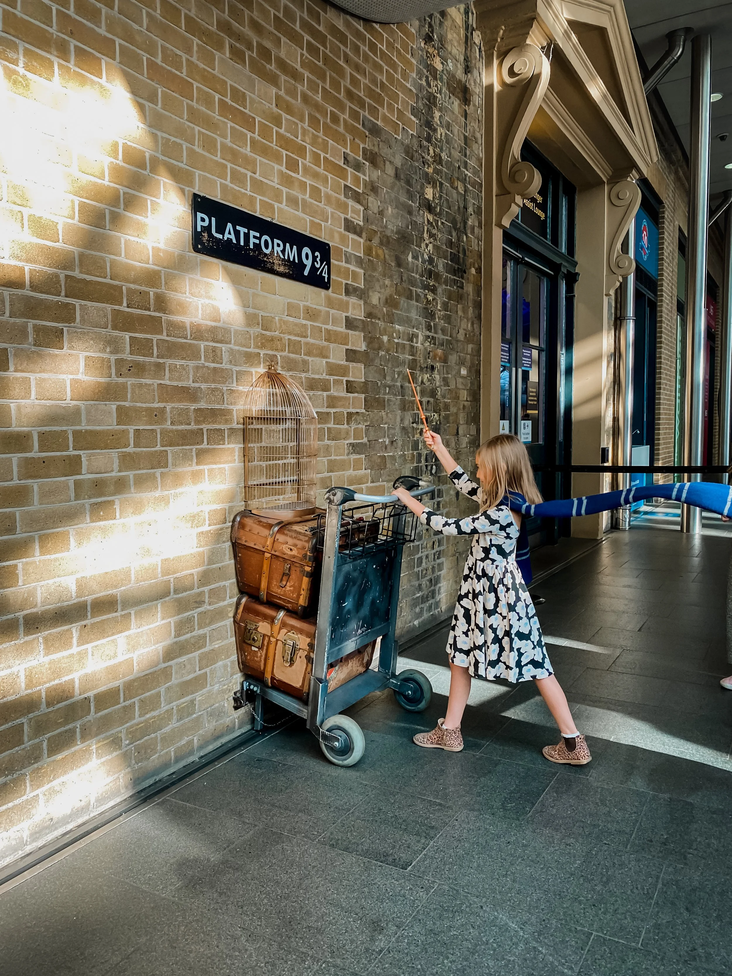A Ravenclaw student walking onto the Platform 9 3/4 at Kings Cross Station in London.