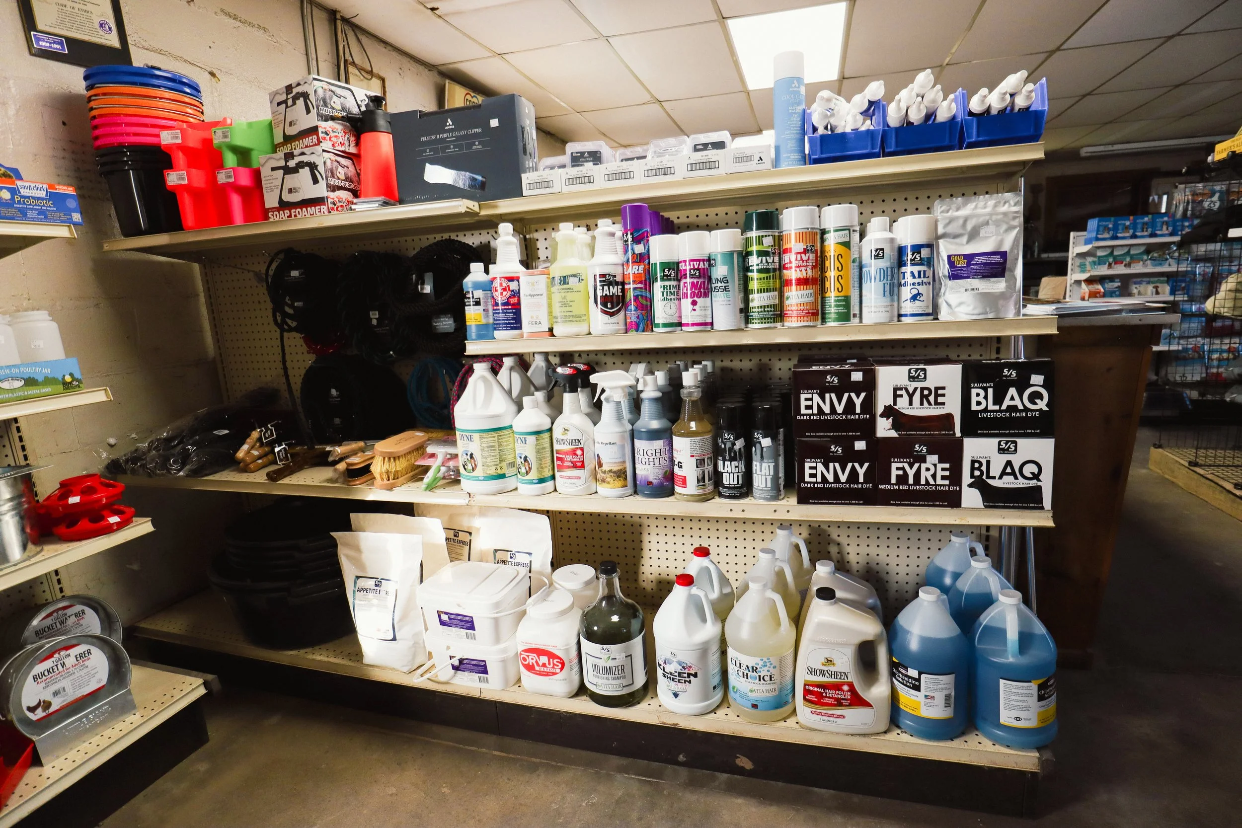 Shelves stocked with pet supplies, grooming products, and cleaning chemicals in a store aisle.