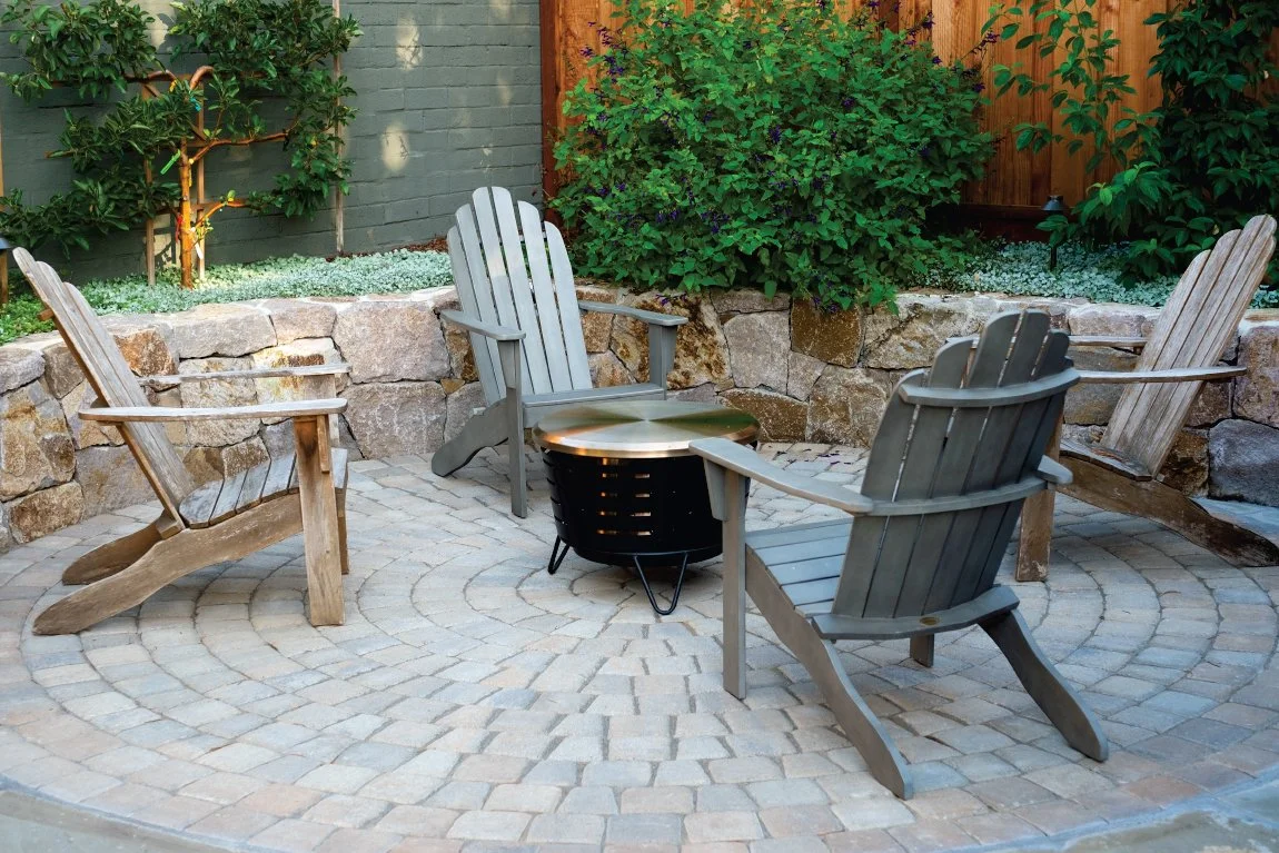 Napa basalt dry stacked stone walls curve around circular paver patio. Outdoor entertainment.